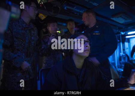 Gewässer, DIE DIE KOREANISCHE HALBINSEL (28. März 2017) Sonar Techniker (Oberfläche) Seaman Raeleen Rosales, front, Monitore Schiff Lager für Kontakte beim Senior Chief Sonar Techniker (Oberfläche) Brian Holzmacher, hinten rechts, erklärt Verfahren zur Republik Korea Marine (ROKN) Segler während im Sonar zentralen Raum der Arleigh-Burke-Klasse geführte Anti-raketen-Zerstörer USS Barry (DDG52). Barry ist die Teilnahme an einer Oberfläche Schiff Anti-Submarine Warfare Bereitschaft und Wirksamkeit messen (SHAREM) Übung, das ist eine multi-nationale Bewegung entwickelt, um die Interoperabilität der USA und R stärken Stockfoto