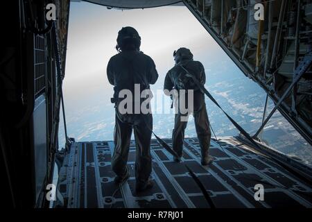 Senior Airman Christopher Godkin und Tech Sgt. Nathan Joslin, 815Th Airlift Squadron loadmasters, beobachten Sie die U.S. Navy Leap Frösche auf dem Weg zur Golfküste Abstieg während eines Sprungs am 4. April. Der Sprung Frösche koordiniert mit dem Fliegenden Jennies dieser Sprung und mehrere andere aus Keesler Air Force Base, Mississippi als gemeinsame Ausbildung für beide Gruppen, die auch in Verbindung mit Marine Woche und dem Mississippi bicentennial Feier war. Stockfoto