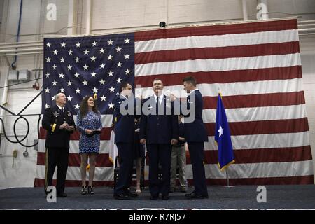 Us Air Force Senior Airman Blayne Cassady (links) und Flieger 1. Klasse Ryan Williams (rechts), 145 Maintenance Squadron, Stift zwei Sterne auf den epaulet von Brig. Gen. Roger E. Williams, Jr. (Mitte), Assistent der Commander, 18 Air Force, Scott Air Force Base, Illinois, während seiner Promotion Zeremonie an der North Carolina Air National Guard Base, Charlotte Douglas International Airport, 1. April 2017 statt. Williams hat im Militär für 32 Jahre gedient und ist die Förderung in den Rang eines Major General. Stockfoto