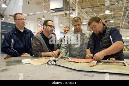 Honorary commander Mike Caloway, 9. Airlift Squadron, und John Yoho, Honorary Commander Alumni, Watch Rob Meding, 436Th Logistik Bereitschaft Squadron Commander ehrenhalber, bereiten Sie ein Flugzeug panel für heiße bonding März 29, 2017, auf Dover Air Force Base, Del. Tech. Sgt. Kenny Pellegrino, 436Th Maintenance Squadron Blech Handwerker, erklärte Meding und die Anderen über jeden Schritt des heißen Klebeverfahren. Stockfoto