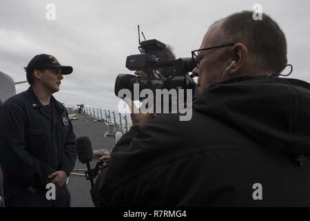 CAPE WRATH, Schottland - (April 3, 2017) - Operations Specialist 3. Klasse Jäger Barton ist während der Übung gemeinsame Krieger 17-1 April 3, 2017 Interview mit einer Übung media Crew an Bord der USS Carney (DDG64). Carney, einem der Arleigh-Burke-Klasse geführte-missile Destroyer, Vorwärts - Rota, Spanien bereitgestellt werden, ist die Durchführung der dritten Patrouille in den USA 6 Flotte Bereich der Maßnahmen zur Unterstützung der US-amerikanischen nationalen Sicherheitsinteressen in Europa. Stockfoto