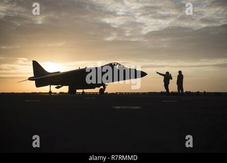 SOUTH CHINA SEA (5. April 2017) Chef der Luftfahrt Bootsmann Mate (Handling) Michael Dominguez, aus Los Angeles, Links, und des Chief Aviation Bootsmann Mate (Handling) Fernando Diaz, aus Brooklyn, N.Y., direkt die Bewegung einer AV-8B Harrier, auf den Grat Läufer der Marine Medium Tiltrotor Squadron (VMM) 163 zugeordnet, es bereitet sich auf den Start. Makin Island, das Flaggschiff der Makin Island amphibischen bereit, mit der begonnen 11 Marine Expeditionary Unit, arbeitet in der Indo-Asia-pazifischen Region amphibische Fähigkeit mit regionalen Partnern zu verbessern und zu dienen als ready-respon Stockfoto