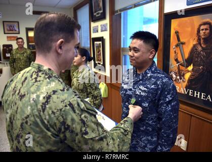 BUSAN, Republik Korea (6. April 2017) hinten Adm. Brad Cooper, Commander, U.S. Naval Forces Korea (CNFK) Auszeichnungen Information Systems Techniker 2. Klasse Karl Lance Carbonel ein Navy und Marine Corps Leistung Medaille während einer Auszeichnungen bei Viertel an CNFK Hauptquartier. CNFK ist Vertreter der U.S. Navy in der ROK, der Leitung und der Kompetenz in der Marine Fragen der institutionellen und operativen Wirksamkeit zwischen den beiden Marinen zu verbessern und der kollektiven Sicherheit Bemühungen in Korea und der Region zu stärken. Stockfoto