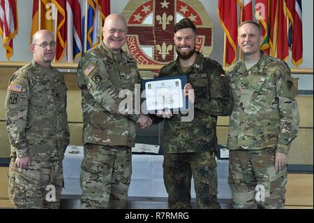 Us-Armee Oberst Brian Almquist, die 212Th Combat Support Hospital Commander, zweiter von links, und der US-Armee Europa Stellvertretender Kommandierender General, Brig. Gen. Phillip S. Jolly, Recht, Vergabe der Experte Bereich Medizinische Abzeichen (EFMB) zu einem deutschen Soldaten während der EFMB Preisverleihung an der 7. Armee den Befehl, Grafenwöhr, Deutschland, 30. März 2017. 215 Kandidaten aus 11 Ländern streben die Abzeichen, die während des 5-tägigen Herausforderung. Die EFMB Wettbewerb stärkt die einzelnen Soldaten Fähigkeiten und stärkt Bindungen mit multinationalen Verbündeten und Partnern. Stockfoto