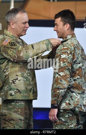 Die US-Armee Europa Stellvertretender Kommandierender General, Brig. Gen. Phillip S. Jolly, Links, Awards der Experte Bereich Medizinische Abzeichen (EFMB) zu einem mazedonischen Soldaten während der EFMB Preisverleihung an der 7. Armee den Befehl, Grafenwöhr, Deutschland, 30. März 2017. 215 Kandidaten aus 11 Ländern streben die Abzeichen, die während des 5-tägigen Herausforderung. Die EFMB Wettbewerb stärkt die einzelnen Soldaten Fähigkeiten und stärkt Bindungen mit multinationalen Verbündeten und Partnern. Stockfoto