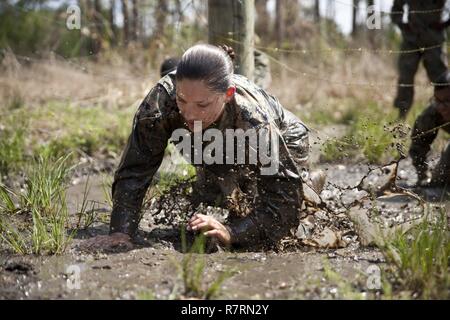Ein US-Marine zu Masse Schule (GSS), Marine Corps Combat Service Support Schulen zugewiesen, kriecht durch den Schlamm während einem Dauerlauf im Camp Johnson, N.C., 29. März 2017. Die Marines der GSS lief an drei verschiedenen Stationen, die auf Hindernisse oder Buddy bestand schleppt und Feuerwehrmann trägt zur Bekämpfung Klimaanlage und Zusammenhalt zu gewährleisten. Stockfoto