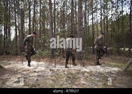 Us-Marines zu Masse Schule (GSS), Marine Corps Combat Service Support Schulen zugewiesen, führen ein Hindernis im Camp Johnson, N.C., 29. März 2017. Die Marines der GSS lief an drei verschiedenen Stationen, die auf Hindernisse oder Buddy bestand schleppt und Feuerwehrmann trägt zur Bekämpfung Klimaanlage und Zusammenhalt zu gewährleisten. Stockfoto