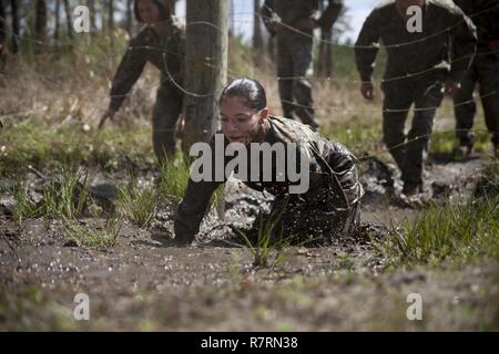 Ein US-Marine zu Masse Schule (GSS), Marine Corps Combat Service Support Schulen zugewiesen, kriecht durch den Schlamm während einem Dauerlauf im Camp Johnson, N.C., 29. März 2017. Die Marines der GSS lief an drei verschiedenen Stationen, die auf Hindernisse oder Buddy bestand schleppt und Feuerwehrmann trägt zur Bekämpfung Klimaanlage und Zusammenhalt zu gewährleisten. Stockfoto
