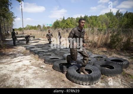Ein US-Marine zu Masse Schule (GSS), Marine Corps Combat Service Support Schulen zugewiesen, führt ein Hindernis bei einem Dauerlauf im Camp Johnson, N.C., 29. März 2017. Die Marines der GSS lief an drei verschiedenen Stationen, die auf Hindernisse oder Buddy bestand schleppt und Feuerwehrmann trägt zur Bekämpfung Klimaanlage und Zusammenhalt zu gewährleisten. Stockfoto