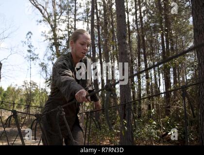 Ein US-Marine zu Masse Schule (GSS), Marine Corps Combat Service Support Schulen zugewiesen, führt ein Hindernis bei einem Dauerlauf im Camp Johnson, N.C., 29. März 2017. Die Marines der GSS lief an drei verschiedenen Stationen, die auf Hindernisse oder Buddy bestand schleppt und Feuerwehrmann trägt zur Bekämpfung Klimaanlage und Zusammenhalt zu gewährleisten. Stockfoto