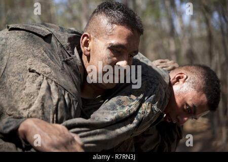 Ein US-Marine zu Masse Schule (GSS), Marine Corps Combat Service Support Schulen zugewiesen, Feuerwehrmann trägt eine Marine während einem Dauerlauf im Camp Johnson, N.C., 29. März 2017. Die Marines der GSS lief an drei verschiedenen Stationen, die auf Hindernisse oder Buddy bestand schleppt und Feuerwehrmann trägt zur Bekämpfung Klimaanlage und Zusammenhalt zu gewährleisten. Stockfoto