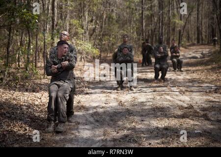 Ein US-Marine zu Masse Schule (GSS), Marine Corps Combat Service Support Schulen zugewiesen, Buddy zieht ein Marine während einem Dauerlauf im Camp Johnson, N.C., 29. März 2017. Die Marines der GSS lief an drei verschiedenen Stationen, die auf Hindernisse oder Buddy bestand schleppt und Feuerwehrmann trägt zur Bekämpfung Klimaanlage und Zusammenhalt zu gewährleisten. Stockfoto