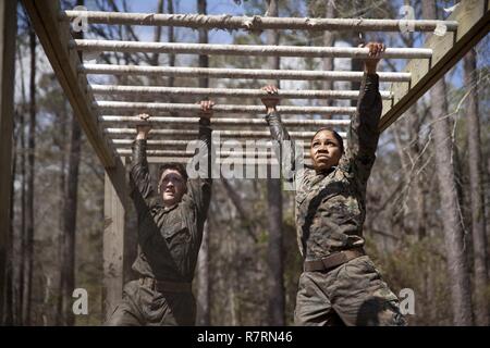 Us-Marines zu Masse Schule (GSS), Marine Corps Combat Service Support Schulen zugewiesen, führen ein Hindernis bei einem Dauerlauf im Camp Johnson, N.C., 29. März 2017. Die Marines der GSS lief an drei verschiedenen Stationen, die auf Hindernisse oder Buddy bestand schleppt und Feuerwehrmann trägt zur Bekämpfung Klimaanlage und Zusammenhalt zu gewährleisten. Stockfoto