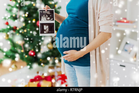 Schwangere Frau mit Ultraschall Bilder zu Weihnachten Stockfoto