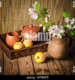 Reifer Apfel und blühenden Zweig von einem Apfelbaum in einem Ton-Glas, Nahaufnahme Stockfoto