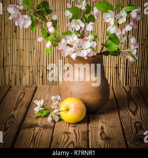 Reifer Apfel und blühenden Zweig von einem Apfelbaum in einem Ton-Glas, Nahaufnahme Stockfoto