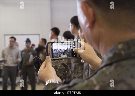 Die Republik Korea Air Force Airman nimmt ein Foto von Rokaf und US Air Force Piloten auf die 621St Contingency Response Flügel, am Joint Base Mc Guire-Dix - Lakehurst, New Jersey stationiert, um sich vorstellen zu einander während der Übung Turbo Verteilung 17-3, in Pohang Air Base, der Republik Korea, April 7, 2017. Die kombinierte Übung ist die erste Schulungsveranstaltung das CRW mit dem ROK durchgeführt hat. Stockfoto