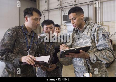 Staff Sgt. Robin McClain, ein Cyber-Techniker die 621St Contingency Response Flügel am Joint Base Mc Guire-Dix - Lakehurst, New Jersey stationiert, Wissen teilt mit zwei Republik Korea Flieger während der Übung Turbo Verteilung 17-3 in Pohang Air Base, der Republik Korea, April 7, 2017. Das CRW spezialisiert sich auf rasch zur Gründung Naben für Cargo Vertrieb weltweit, die Fernbedienung und die strengen Standorte, kurzfristig zu gehören. Stockfoto