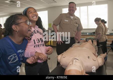 Portsmouth, Virginia (April 7, 2017) eine Gruppe von 6 Sortierer von Park View Volksschule Lachen nach dem Hören der Puppe schreien, weil einer der Simulation Techniker geändert Stimme Modulator der Schaufensterpuppe. Mehr als ein Dutzend Mitarbeiter von Naval Medical Center Portsmouth in Career Day an der Grundschule in Portsmouth mit der Einrichtung von drei Interaktive Wissenschaft, Technologie, Ingenieurwesen und Mathematik (STEM) - Ähnliche Stationen in Science Lab der Schule teilgenommen. Stockfoto