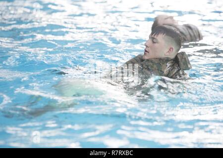 Ein Marine erstellt eine Verstellung mit Utility Hose während Wasser gerät Survival-Advanced Ausbildung in Camp Lejeune, N.C., April 4, 2017. WSA stellt Marines die Möglichkeit qualifizierte Rettungs Schwimmer zu werden. Die Marine ist ein Student in den Kurs, der von der 2. Strafverfolgung Bataillon ausgeführt wird. Stockfoto