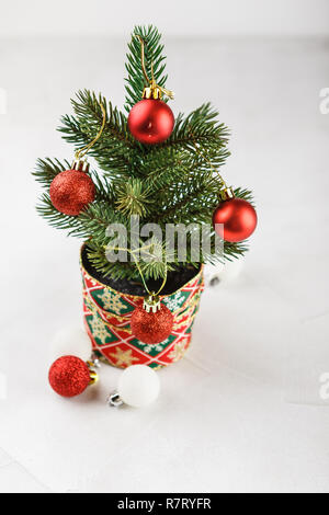 Kleine geschmückten Weihnachtsbaum mit roten Glocken auf Weiß Stockfoto