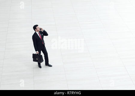 Ansicht von oben aus der Ferne. Geschäftsmann mit einem Mobiltelefon Stockfoto