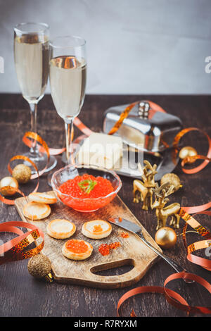 Törtchen mit rotem Kaviar, Champagner und Butter auf einem festlich gedeckten Tisch. Traditionelle russische Weihnachten oder Urlaub das Neue Jahr Tabelle Stockfoto