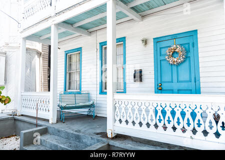 Key West, USA - Mai 1, 2018: Weiß und Blau Architektur des Hauses in Florida City Island auf Reisen, sonnigen Tag, Kranz und Bank auf der Veranda Eingang von p Stockfoto