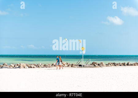 Key West, USA - Mai 1, 2018: die Menschen zu Fuß von Pier park mit man Surfen, Kitesurfen mit Kite auf dem Tragflügelboot in Florida an das Meer, auf das Meer in der Nähe von Beac Stockfoto