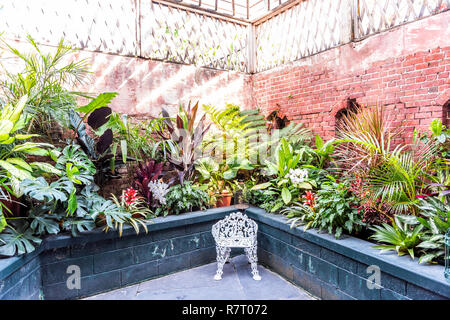 Key West, USA - Mai 1, 2018: Brick Festungsmauer und Pflanzen Blumen in Martello botanischen Garten Center mit kleinen Bank, Architektur in Florida Stockfoto