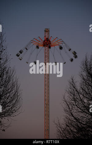 Rund um die Welt XXL-Achterbahn auf der South Bank, London, in der Abenddämmerung mit Licht. Messe Fahrt mit Menschen in den Stühlen hängen von rotierenden Arme Stockfoto