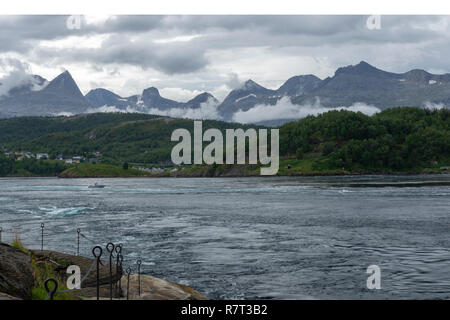 Blick nach Süden über Saltstraumen eines der stärksten Gezeiten in der Welt mit børvasstindene Berge und einem bewölkten Himmel im Hintergrund, Pic Stockfoto