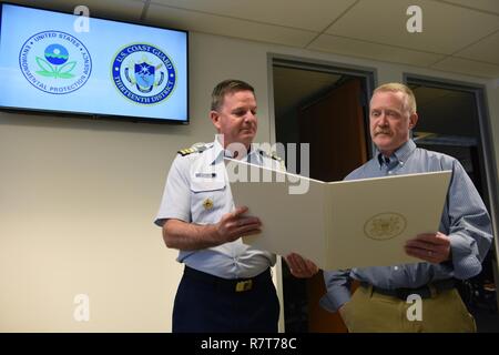 Kapitän Brendan McPherson, Stabschef, Coast Guard 13. Bezirk, präsentiert die verdienstvollen Public Service Award an Chris Field, Emergency Response Program Manager für die U.S. Environmental Protection Agency, April 6, 2017. Feld zieht sich am 26.04.29, 2017, mit 31 Jahren der föderale Dienst, 28 von denen, die er an der EPA serviert. Us-Küstenwache Stockfoto