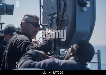 Pazifik (5. April 2017) Matrosen an Bord der Ticonderoga-Klasse geführte-missile Cruiser USS Lake Erie (CG70) installieren Sie einen Long Range Acoustic Device (LRAD) während der Fahrt die Durchführung einer Composite Trainingsgerät Übung (COMPTUEX) mit der nimitz Carrier Strike Group in Vorbereitung für eine bevorstehende Bereitstellung. COMPTUEX Tests die Mission - Bereitschaft der Aktiva der Streik Gruppe durch simulierte Szenarien und ihre Fähigkeit als integrierte Einheit durchzuführen. Stockfoto