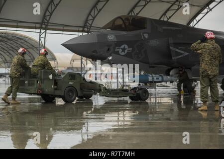 Us-Marines mit Marine Fighter Attack Squadron (Vmfa) 121 Last ordnance an einer F-35B Blitz II Flugzeuge während der heißen - laden Sie die Ausbildung bei der Marine Corps Air Station Iwakuni, Japan, April 6, 2017. Dies bedeutete, das erste Mal die Squadron ordnance auf eine laufende F-35B Blitz II Flugzeuge der Air Station geladen, um für reale Szenarios vorzubereiten. Stockfoto