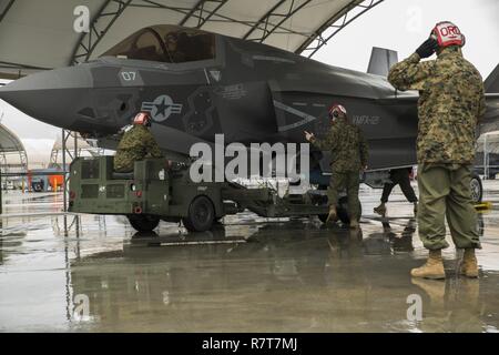 Us-Marines mit Marine Fighter Attack Squadron (Vmfa) 121 Last ordnance an einer F-35B Blitz II Flugzeuge während der heißen - laden Sie die Ausbildung bei der Marine Corps Air Station Iwakuni, Japan, April 6, 2017. Dies bedeutete, das erste Mal die Squadron ordnance auf eine laufende F-35B Blitz II Flugzeuge der Air Station geladen, um für reale Szenarios vorzubereiten. Stockfoto