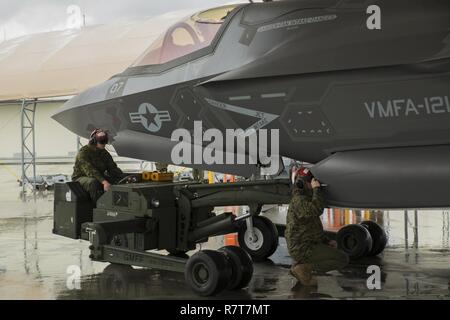 Us-Marines mit Marine Fighter Attack Squadron (Vmfa) 121 Last ordnance an einer F-35B Blitz II Flugzeuge während der heißen - laden Sie die Ausbildung bei der Marine Corps Air Station Iwakuni, Japan, April 6, 2017. Dies bedeutete, das erste Mal die Squadron ordnance auf eine laufende F-35B Blitz II Flugzeuge der Air Station geladen, um für reale Szenarios vorzubereiten. Stockfoto