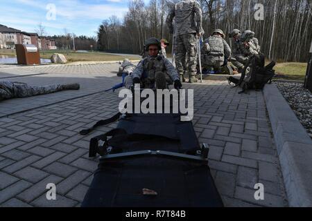 Senior Airman Nigel Crudgington, 100 Sicherheitskräfte Squadron Rüstung Techniker, wird ein Wurf einer simulierten verletzten Flieger während der Tactical combat Casualty care Teil der 435th Security Forces Squadron Bodenkampf Bereitschaft Training Center Security Operations Kurs auf der Air Base Ramstein, Deutschland, 30. März 2017 zu transportieren. Flieger zum 86Th SFS, 422Nd SFS, 100 SFS zugewiesen und 569th US-Streitkräfte Polizei Geschwader nahmen an dem Kurs. Stockfoto