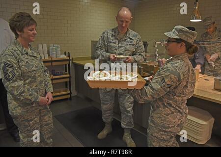 Oberst Ryan Samuelson, 92nd Air Refuelling Wing Commander, und Chief Master Sgt. Shannon Rix, 92. ARW Befehl Chief, Geschmack Testen neuer Krieger Mission wichtig Fütterung Werk Optionen während eines Ribbon Cutting 27.03.2017, bei Fairchild Air Force Base, Washington. Senior Airman Samantha Acevedo, 92nd Force Support Squadron Dienstleistungen Facharbeiter, präsentierte die gesündere, Ciao Pizzeria Führung zu stützen. Stockfoto