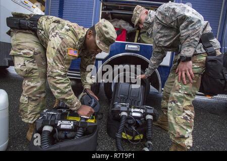 Übersicht Teammitglieder Sgt. Koran Williams, Links, und Staff Sgt. Nicky Lam, beide mit 21 Waffen der New Jersey National Guard von Mass Destruction-Civil Support Team, Zusammenbauen BG4 rebreather Einheiten bei einer gemeinsamen Übung mit den Mitgliedern der Monmouth County Hazmat Team in Fort Monmouth, New Jersey, April 6, 2017. Das 21 WMD-CST ist eine gemeinsame Einheit aus New Jersey National Guard Soldaten und Piloten, deren Aufgabe es ist, die zivilen Autoritäten durch die Identifizierung von chemischen, biologischen, radiologischen und nuklearen Stoffen entweder in man-made oder Naturkatastrophen. (New Jersey National Guard Stockfoto