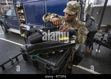 Umfrage Teammitglied Sgt. Koran Williams mit 21 Waffen der New Jersey National Guard von Mass Destruction-Civil Support Team, ersetzt eine Batterie in einer BG4 rebreather Einheit im Rahmen einer gemeinsamen Übung mit den Mitgliedern der Monmouth County Hazmat Team in Fort Monmouth, New Jersey, April 6, 2017. Das 21 WMD-CST ist eine gemeinsame Einheit aus New Jersey National Guard Soldaten und Piloten, deren Aufgabe es ist, die zivilen Autoritäten durch die Identifizierung von chemischen, biologischen, radiologischen und nuklearen Stoffen entweder in man-made oder Naturkatastrophen. (New Jersey National Guard Stockfoto