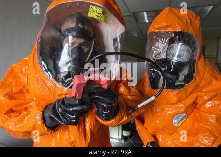 Staff Sgt. Nicky Lam, Links, und Sgt. Koran Williams, beide mit 21 Waffen der New Jersey National Guard von Mass Destruction-Civil Support Team die Ergebnisse eines Handhelds chemische Identifizierung Analyzer bei einer simulierten Lab Website bei einer gemeinsamen Übung mit den Mitgliedern der Monmouth County Hazmat Team in Fort Monmouth, New Jersey, April 6, 2017. Das 21 WMD-CST ist eine gemeinsame Einheit aus New Jersey National Guard Soldaten und Piloten, deren Aufgabe es ist, die zivilen Autoritäten durch die Identifizierung von chemischen, biologischen, radiologischen und nuklearen Stoffen entweder in künstliche oder natürliche Stockfoto