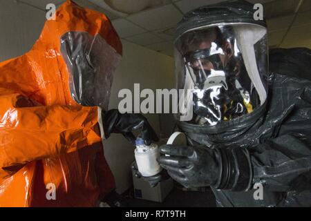 Sgt. Koran Williams, Links, eine Probe in einem Beweis Container von Sgt. Cory Sweetman, beide mit 21 Waffen der New Jersey National Guard von Mass Destruction-Civil Support Team, bei einem gemeinsamen Training in Fort Monmouth, New Jersey, April 6, 2017. Das 21 WMD-CST ist eine gemeinsame Einheit aus New Jersey National Guard Soldaten und Piloten, deren Aufgabe es ist, die zivilen Autoritäten durch die Identifizierung von chemischen, biologischen, radiologischen und nuklearen Stoffen entweder in man-made oder Naturkatastrophen. (New Jersey National Guard Stockfoto