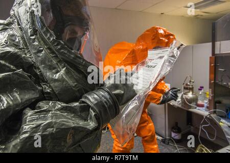 Sgt. Cory Sweetman, Links, ein Beweis Tasche beschriftet, während Sgt. Koran Williams, beide mit 21 Waffen der New Jersey National Guard von Mass Destruction-Civil Support Team, Fotos einer simulierten Lab Website bei einem gemeinsamen Training in Fort Monmouth, New Jersey, April 6, 2017. Das 21 WMD-CST ist eine gemeinsame Einheit aus New Jersey National Guard Soldaten und Piloten, deren Aufgabe es ist, die zivilen Autoritäten durch die Identifizierung von chemischen, biologischen, radiologischen und nuklearen Stoffen entweder in man-made oder Naturkatastrophen. (New Jersey National Guard Stockfoto