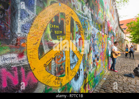 Prag John Lennon Mauer, mit Blick auf ein strassenmusikant spielt eine Gitarre neben den John Lennon Mauer in der Mala Strana Viertel von Prag, tschechische Republik. Stockfoto
