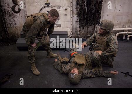 Marines mit Echo Company, Bataillon Landung Team, 2nd Battalion, 5th Marine Regiment, Durchführung von Abschlussprüfungen für eine Combat Life Saver Klasse an Bord der USS Green Bay LPD (20), am Meer, Jan. 31, 2017. Die Marines sind derzeit auf Patrouille als Bodenkampf Element für die 31 MEU. Wie das Marine Corps' nur kontinuierlich vorwärts - bereitgestellt, Luft - Boden - die 31 Marine Expeditionary Unit Logistik Team bietet eine flexible Kraft, bereit, eine breite Palette von militärischen Operationen auszuführen, von begrenzt zur Bekämpfung der humanitären Hilfsmaßnahmen, der gesamten Indo-Asia-Pazifik-Region. Stockfoto