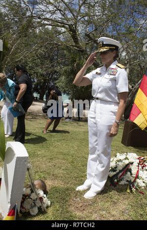 HAGÅTÑA, Guam (7. April 2017) - hinten - Adm. Smilla Chatfield, gemeinsame Region Marianas Commander es grüßt ein Grab eines gefallenen Deutschen Sailor verloren in den Untergang der SMS Cormoran im 100. Jahr nach der Versenkung in Apra Harbor. Stockfoto