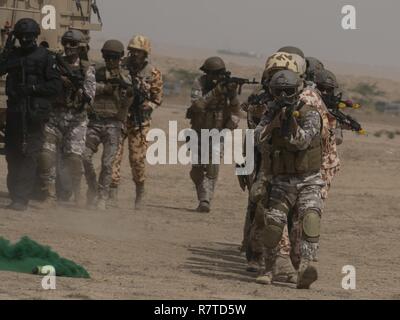 Ein Team von multinationalen Special Operations Forces Ansätze ein paar Gebäude von "Terroristen" während einer Übung in Kuwait. Soldaten von Unternehmen B, 3rd Battalion, 8th Cavalry Regiment, 3. gepanzerte Brigade Combat Team, 1.Kavallerie Division spielte die gegnerische Streitmacht für eine gemeinsame Übung zwischen US Special Operations Forces und SOF Elemente aus Katar, Kuwait, Saudi-Arabien und den Vereinigten Arabischen Emiraten. Stockfoto