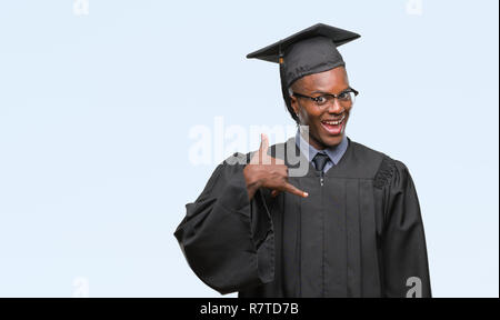 Junge graduierte afrikanische amerikanische Mann über isolierte Hintergrund lächelnd tun Telefon Geste mit der Hand und der Finger wie im Gespräch am Telefon. Communi Stockfoto