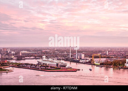 Rotterdam, die Niederlande, November 12, 2018: ein rosa Himmel bei Sonnenuntergang über die Nieuwe Maas und Maashaven Hafen mit ehemaligen cruiseship SS Rotterdam, Stockfoto